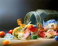 a jar filled with lots of candy sitting on top of a table next to other candies