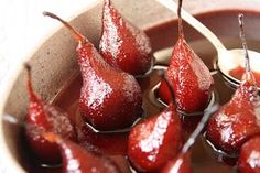 some pears are sitting in a bowl with syrup