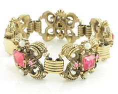 "Vintage Victorian Revival Pink Rhinestone Imitation Pearl Bracelet and Clip On Earring Set. The chunky gold tone bracelet and earrings are set with square and round pink rhinestones and simulated glass pearls. The bracelet links are connected by book link style links. The bracelet is 7 inches long and 15/16 inch wide and the earrings measure approximately 7/8 inch X 1 inch. Finished with a fold over clasp. In Excellent Vintage Condition with no damage noted. ERA: Retro, 1950s METAL/MATERIALS: G Vintage Rhinestone Jewelry For Vintage Events, Vintage Rhinestone Jewelry For Formal Occasions, Vintage Jeweled Jewelry For Evening, Vintage Formal Jewelry With Rhinestones, Vintage Jeweled Bracelets For Party, Antique Jeweled Jewelry For Vintage Events, Vintage Collectible Jewelry With Stone Setting, Retro Jeweled Wedding Jewelry, Collectible Vintage Jeweled Jewelry