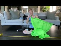 a woman is sitting on the floor with a green cloth in her hand and she is measuring