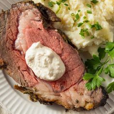 a plate with meat, mashed potatoes and garnish on it is shown