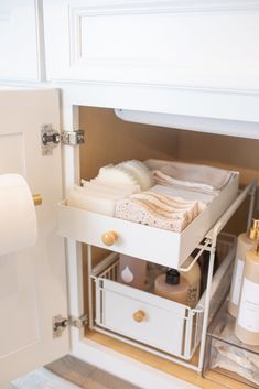 an open drawer in a bathroom with toilet paper