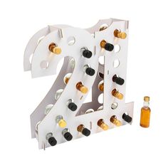 a white and gold number shaped wine rack with two bottles in front of it on a white background