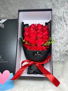 a bouquet of red roses in a black box