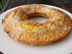 a white plate topped with a donut covered in powdered sugar