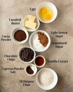 ingredients to make chocolate chip cookies laid out in small bowls on a counter top, including eggs, sugar, cocoa, and flour