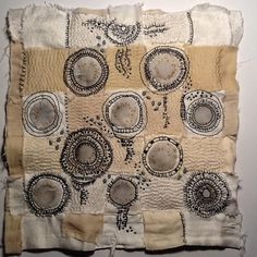 an old piece of cloth with circles and dots on it, hanging on a wall