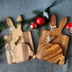 two wooden cutting boards with christmas decorations on them and one is shaped like a rabbit