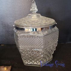 a glass jar with a metal lid sitting on a table