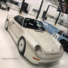 two white porsches are parked in a garage