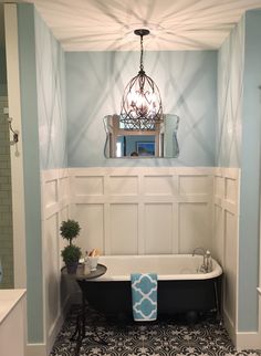 a bath tub sitting under a mirror in a bathroom