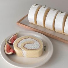 a white plate topped with slices of cake next to sliced figs