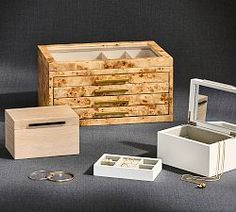 an assortment of jewelry boxes and rings on a gray surface with one open, the other closed