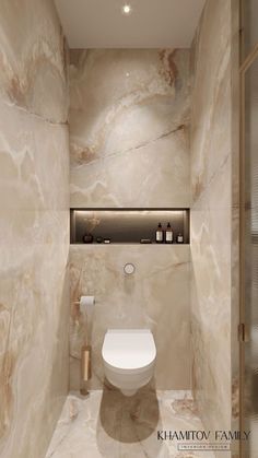 a bathroom with marble walls and flooring is shown in this image, there is a toilet next to the wall