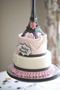 a pink and black cake with the eiffel tower on top