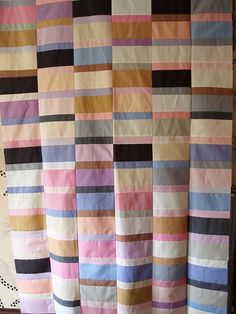 a multicolored quilt is hanging on the wall