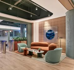 a living room filled with lots of furniture next to a tall planter on top of a hard wood floor