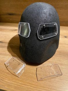 a black helmet with goggles on it sitting on a table next to two clear plates