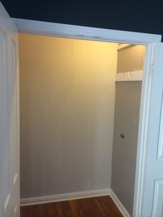 an empty room with white walls and wood flooring in front of the closet door