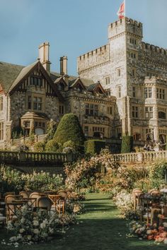 an old castle like building with lots of flowers around it