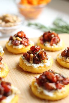 four stuffed tomatoes with cheese and olives on a red and white checkered tablecloth