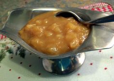 a spoon with some food in it sitting on a silver plate next to a red and white napkin