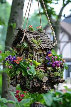 a bird house with flowers hanging from it's roof