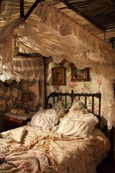 an old fashioned bed is covered with white lace