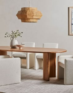 a dining room table with white chairs and a basket hanging from the ceiling