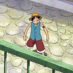 a cartoon character standing on top of a stone wall next to a green rail and fence