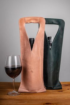 two wine bags and a glass on a table