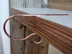 a close up of a metal hook on a wooden door