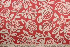 a red and white floral print on fabric with a ruler in front of the image