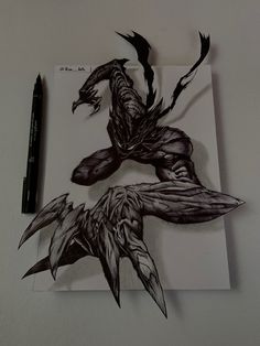 a drawing of a creature on paper next to a pen