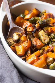 a white bowl filled with cooked vegetables on top of a table