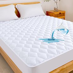 an image of a bed with water splashing on it's mattress topper