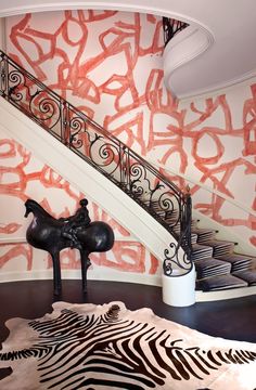 the stairs in this house are decorated with pink paint and black iron railings, along with a zebra print rug