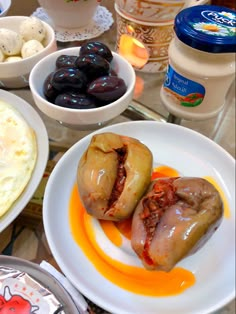 an assortment of food items displayed on plates and bowls with utensils in the background