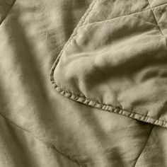 an image of a close up view of a quilted bedding with buttons on it