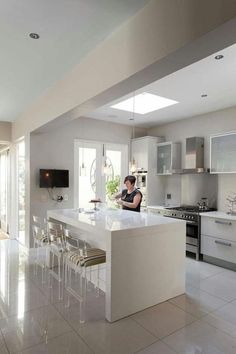 a woman is sitting at the kitchen counter