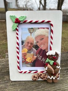 an old man and woman are sitting next to a christmas frame