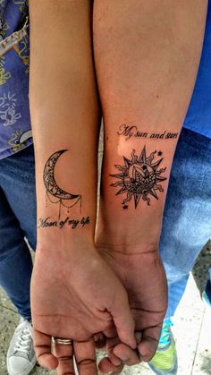 two people are holding hands with tattoos on their arms and the words moon and sun