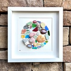 a white frame with some colorful rocks in it