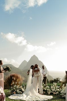 the bride and groom are kissing at their wedding ceremony in front of the beautiful mountains