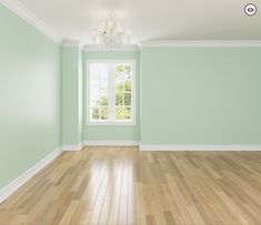 an empty room with light green walls and wood floors