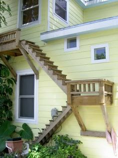 a yellow house with stairs leading up to the second floor