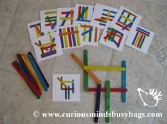 several pieces of colored wooden stick art on the floor with one piece cut out to look like letters