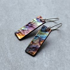 Colorful Patina Copper Earrings * Handmade Jewelry  Each earring is hand-cut from copper and then hammered for texture. The beautiful colors are created by heating the copper with a flame. (Earrings are sealed to help protect the colorful patina)  Matching Pendant https://www.etsy.com/listing/1644963198/colorful-copper-pendant These earrings are approximately 1 1/4 inches long including the sterling silver ear wire.  Due to the nature of flame painting, the earrings you receive may vary slightly from the pair in the photos - colors and vibrancy may be different. Colors are only on one side All jewelry comes wrapped in eco-friendly packaging. Patina Jewelry Ideas, Flame Earrings, Copper Earrings Handmade, Enameling Jewelry