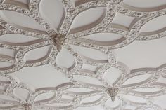 an intricate ceiling with white paint and decorative designs on the ceiling, is shown in this image