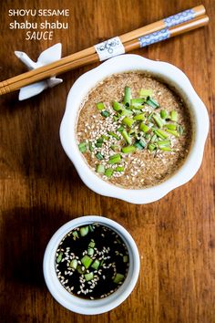 two bowls of food on a table with chopsticks next to one bowl filled with soup